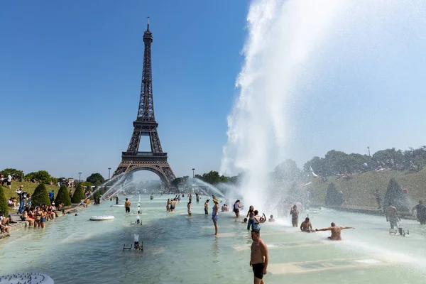 パリ、フランス、2019年6月27日:観光客や地元の人々は、強力な水の大砲の下でトロカデロのジャルダン・デュ・トロカド・ロ・ガーディアンズでお風呂に入ります。45度セリウス以上の新しい熱記録 — ストック写真