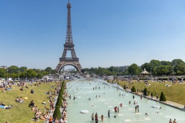 Paris, Fransa, 27 Haziran 2019: Turistler ve yerliler güçlü tazyikli su altında Trocadero'nun Jardins du Trocad ro Guardians'ında banyo yapıyor. 45 derece celius üzerinde yeni ısı kayıtları