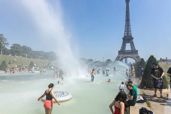 Parigi, Francia, 27 giugno 2019: turisti e gente del posto fanno il bagno nei Jardins du Trocad ro Guardiani del Trocadero sotto i potenti cannoni ad acqua. nuovo record di calore oltre 45 gradi celiaci — Foto Stock