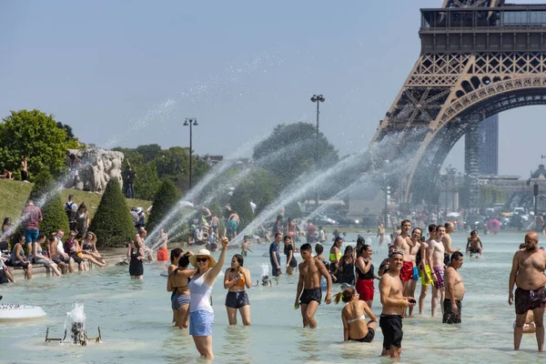 पॅरिस, फ्रान्स, जून 27, 2019: पर्यटक आणि स्थानिक लोक शक्तिशाली पाण्याच्या तोफाखाली ट्रॉकडेरोच्या जॅर्डीन डू ट्रॉकड रो पालकांमध्ये आंघोळ करतात. ४५ अंश सेल्सियस तापमानाची नोंद — स्टॉक फोटो, इमेज