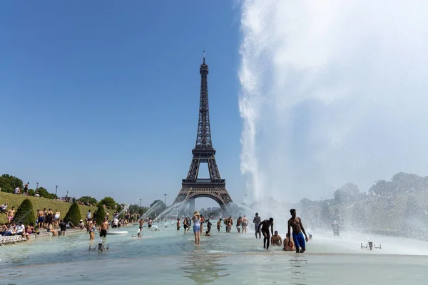 Παρίσι, Γαλλία, 27 Ιουνίου 2019: τουρίστες και ντόπιοι που κάνουν μπάνιο στο Jardins Du Trocad ro φύλακες του Τροκαντερό κάτω από τα ισχυρά κανόνια νερού. νέα αρχεία θερμότητας πάνω από 45 μοίρες — Φωτογραφία Αρχείου