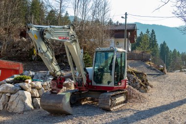 Eibsee, Almanya, 31 Mart 2019: Turizm sezonu başlamadan önce bir inşaat sahasında büyük bir kazıcı
