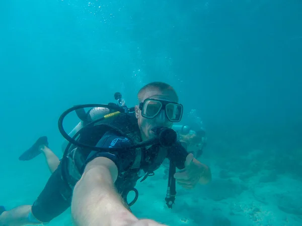 GREAT BARRIER REEF, AUSTRALIA - OCT 13, 2015: Scuba diving man tourist made a thumbs up for show everything is fine