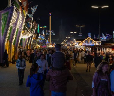 Munich, Germany - 2019 September 24: a father is carrying his young son on his shoulders on the oktoberfest in munich at night