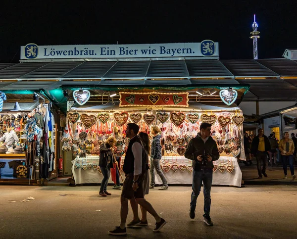 ミュンヘン,ドイツ- 2019年9月24日:夜にミュンヘンで開催されるオクトーバーフェストの来場者、来場者、キャンディーショップ — ストック写真