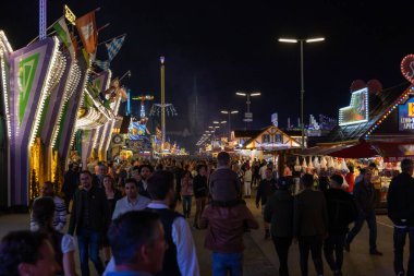 Munich, Germany - 2019 September 24: a father is carrying his young son on his shoulders on the oktoberfest in munich at night