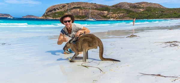 Hombre caucásico con un hermoso canguro en Lucky Bay Beach en el Parque Nacional Cape Le Grand cerca de Esperance, Australia — Foto de Stock