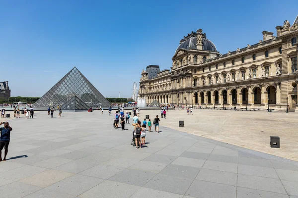 Parigi, Francia - 27 giugno 2019: Veduta della piramide e della fontana nel cortile del Museo del Louvre. Il Museo del Louvre è uno dei musei più grandi e visitati al mondo. — Foto Stock