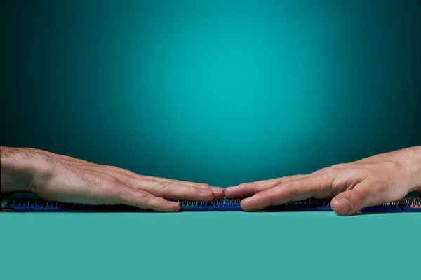 The guy 's hands lies with left and right on a barbed massage mat on an ocean background. side view. healthy lifestyle. Thematic and promotional photography. For relaxation and health.