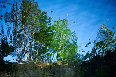 Gölün sularındaki ağaçların ve taş dağların güzel yansıması. Doğa, kanyon ve gökyüzü. Bulanık resim.