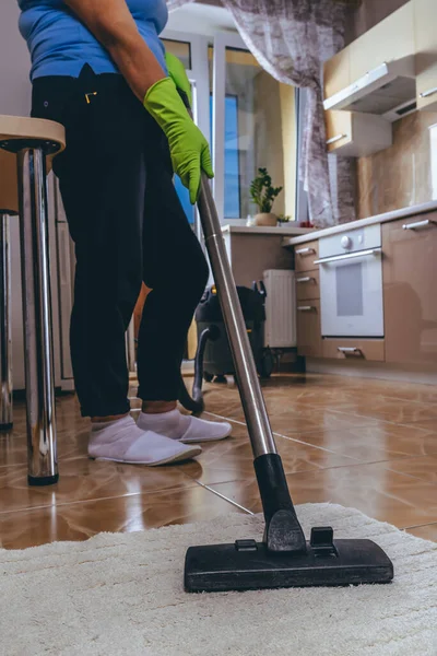 女性の掃除機は掃除機で台所のカーペットをきれいにします アパートの掃除だ いい助手だ 家の掃除だ 微生物を殺す プロセス — ストック写真