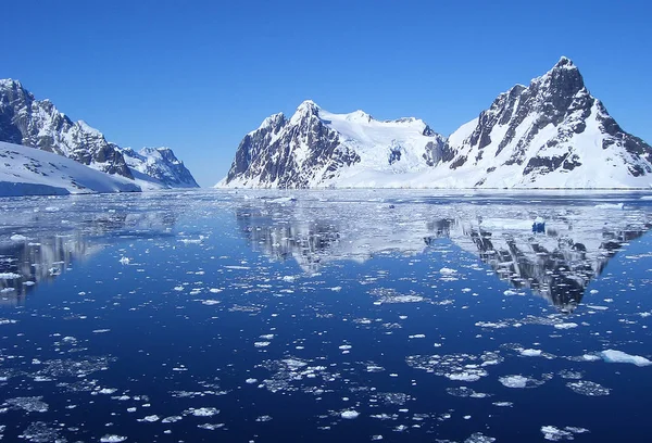 Beautiful Antarctic landscape with ocean, icebergs and reflection on a sunny day