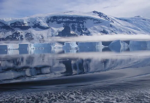 Beautiful Antarctic landscape with ocean, icebergs and reflection on a sunny day