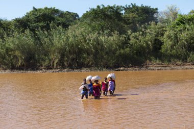 Madagaskar Malagasy kadınlar güneşli bir günde kargo ile bir nehir fording