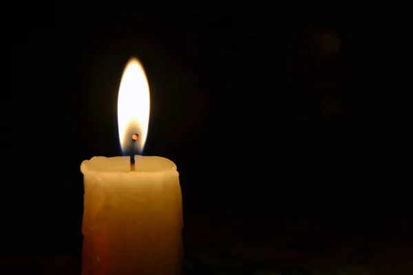 Einzelkerze aus nächster Nähe einsame Kerze aus nächster Nähe auf schwarzem Hintergrund Stockbild