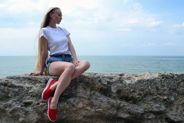 Giovane donna in t-shirt bianca rilassante sul mare — Foto Stock