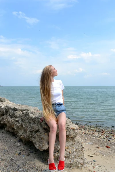 Giovane donna in t-shirt bianca rilassante sul mare — Foto Stock