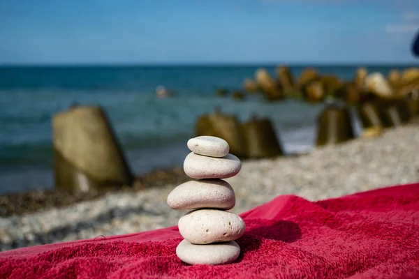 Kamienie ułożone piramidy na plaży z błękitne niebo i morze. — Zdjęcie stockowe