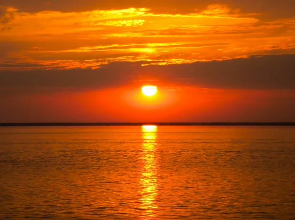 Atardecer rojo sobre el mar, rico en nubes oscuras, rayos de luz Imágenes De Stock Sin Royalties Gratis