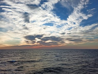 Sakin bir havada denizin üzerinde gün batımı.