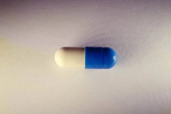 Prášek bílá a modrá zblízka. Tobolky léku. — Stock fotografie