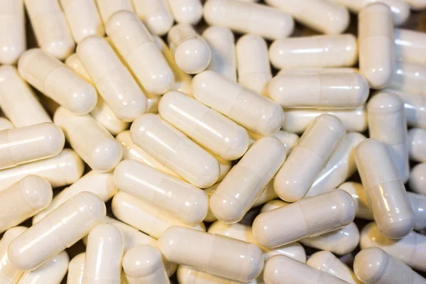 A handful of white pills close-up. Capsules medication is white.