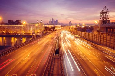 Yol çok araba arka planda metropol ışıklarını ile gece. Gece ışıkları ve arabalar.