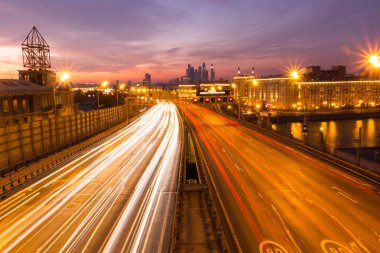 Yol çok araba arka planda metropol ışıklarını ile gece. Gece ışıkları ve arabalar.