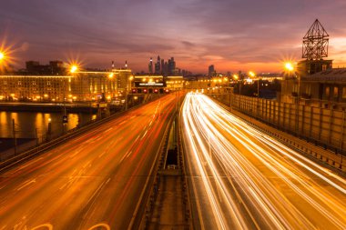 Yol çok araba arka planda metropol ışıklarını ile gece. Gece ışıkları ve arabalar.