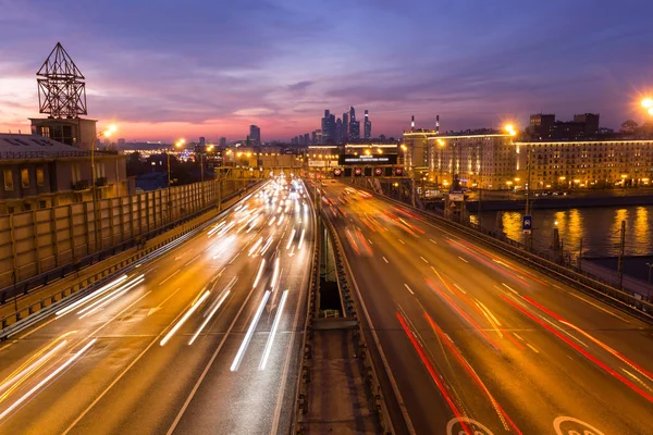 Yol çok araba arka planda metropol ışıklarını ile gece. Gece ışıkları ve arabalar.