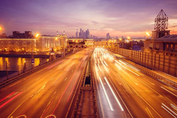 Yol çok araba arka planda metropol ışıklarını ile gece. Gece ışıkları ve arabalar.