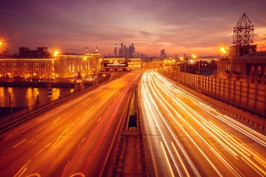 Yol çok araba arka planda metropol ışıklarını ile gece. Gece ışıkları ve arabalar.