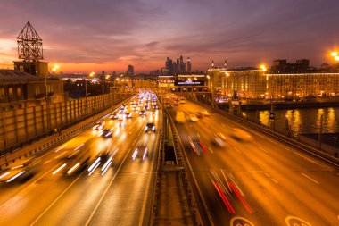 Yol çok araba arka planda metropol ışıklarını ile gece. Gece ışıkları ve arabalar.