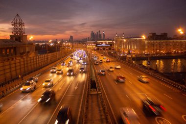 Yol çok araba arka planda metropol ışıklarını ile gece. Gece ışıkları ve arabalar.