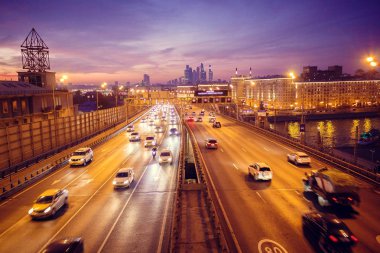 Yol çok araba arka planda metropol ışıklarını ile gece. Gece ışıkları ve arabalar.