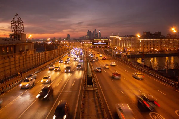 Yol çok araba arka planda metropol ışıklarını ile gece. Gece ışıkları ve arabalar.