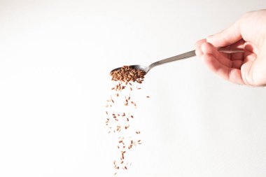 Keten tohumu avuç kaşık gelen aşağı düşüyor. Beyaz