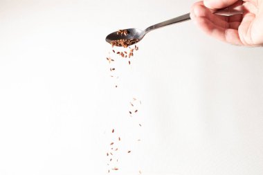 Keten tohumu avuç kaşık gelen aşağı düşüyor. Beyaz