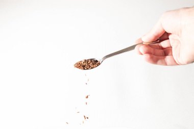 Keten tohumu avuç kaşık gelen aşağı düşüyor. Beyaz