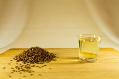 Keten tohumu avuç, keten tohumu yağı bir bardak masanın üzerine