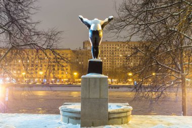 Kız yüzücü arkadan görünüm anıt. Anıtın üzerinde park kış akşamları kar.