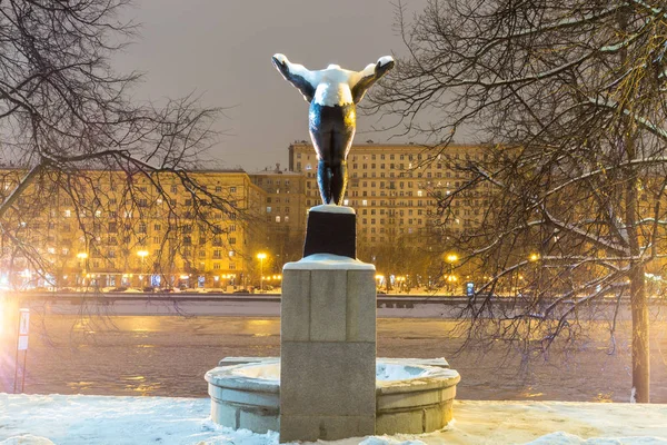 Kız yüzücü arkadan görünüm anıt. Anıtın üzerinde park kış akşamları kar. — Stok fotoğraf