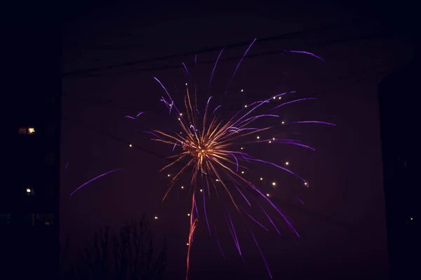 Nachtgruß. Explosionslinien in verschiedenen Farben. Ausbrüche zwischen Häusern. — Stockfoto