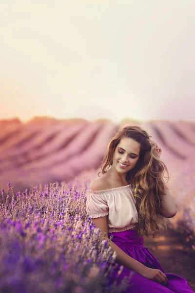 Jonge vrouw met charmante glimlach in Lavendel veld bij zonsondergang. Portret van Beautiful gelukkig meisje in lavendel. — Stockfoto
