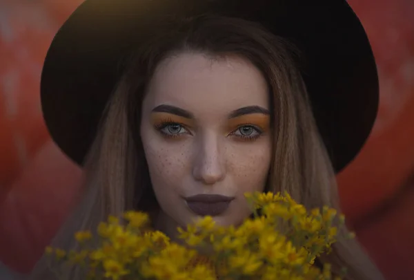 Confortable portrait photo d'automne d'une fille dans un chapeau et fleurs jaunes . — Photo