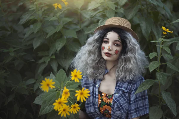 La chica es un espantapájaros en un campo con flores amarillas . —  Fotos de Stock