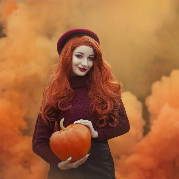 Menina ruiva com abóbora na fumaça de laranja. Mulher no fundo laranja outono . — Fotografia de Stock