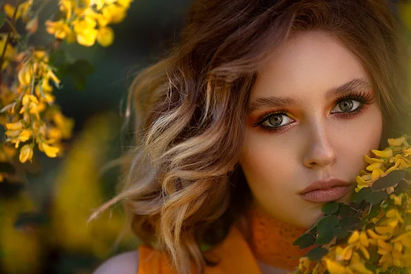 Portret van een mooie sensuele vrouw op een achtergrond van een gele bloesemboom. Zomer tijd, zomer kleuren. — Stockfoto