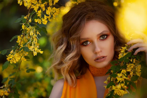 黄色の花の木の背景にかなり官能的な女性の肖像画。夏、夏の色. — ストック写真