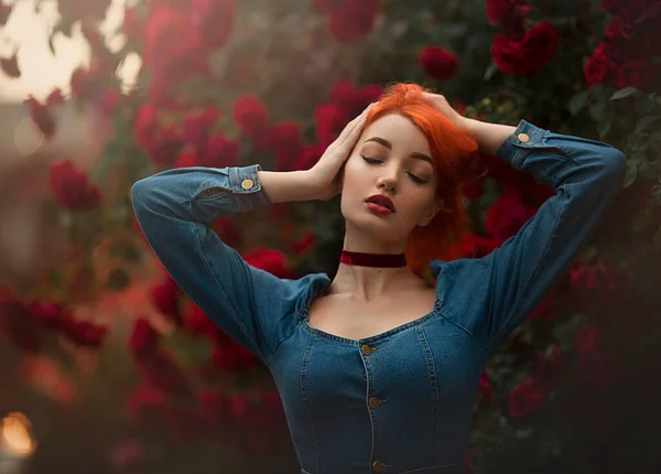 Retrato de sensual chica pelirroja con los ojos cerrados en un vestido azul. Bonita joven modelo entre rosas rojas. Obra artística . —  Fotos de Stock